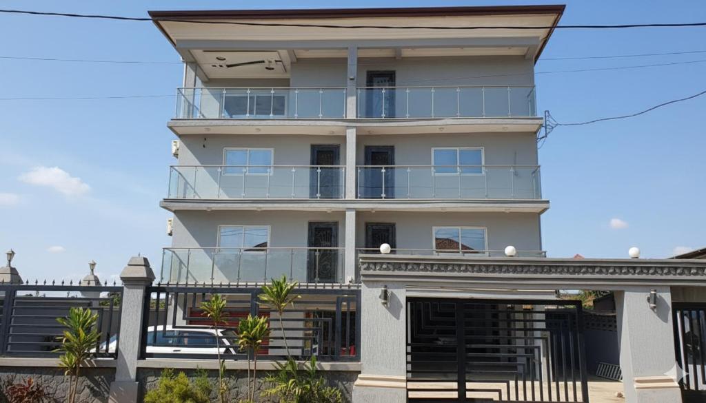 a tall white building with a balcony at Duswin Hotel Gloucester, Freetown, SL in Freetown