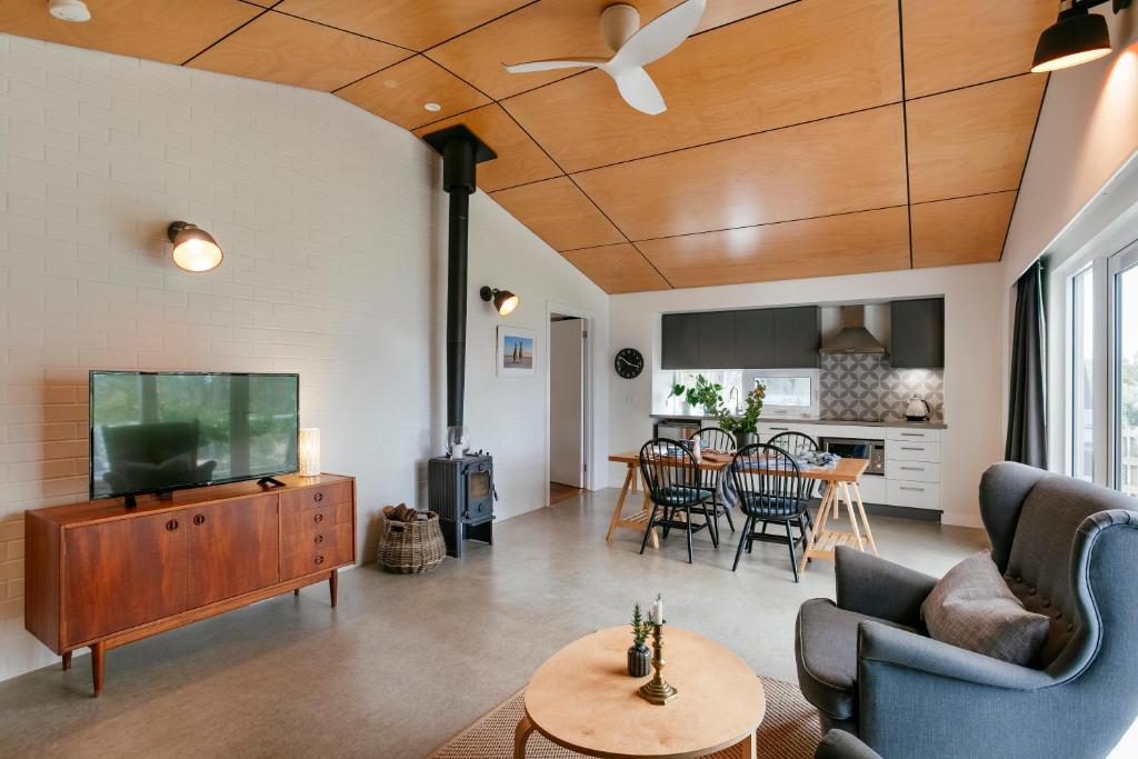 a living room with a flat screen tv and a table at Stablebase in Albany