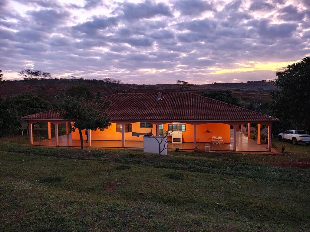 a yellow house with a car parked in front of it at Area de Lazer Rural in Ribeirão Preto