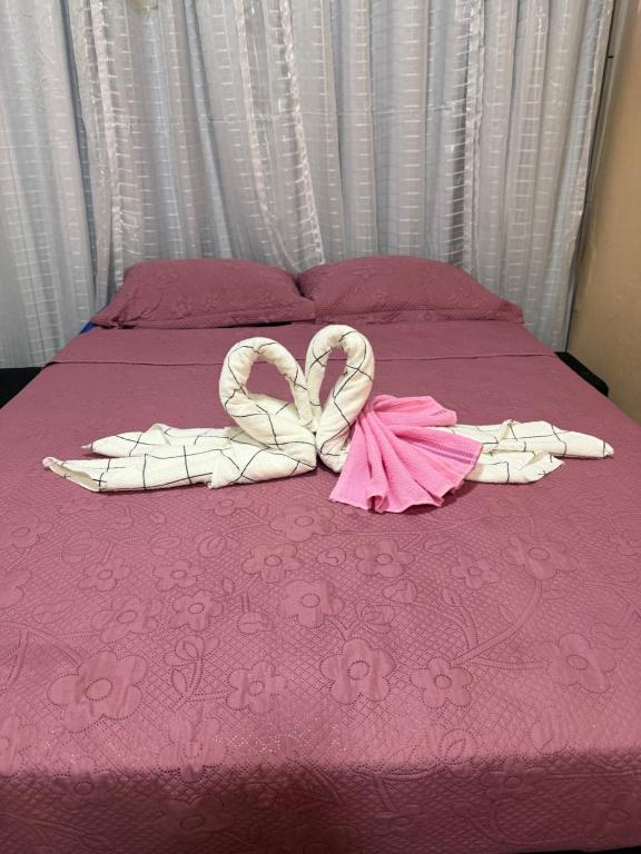 a bed with two heart shaped towels on it at Sol e mar in Serra
