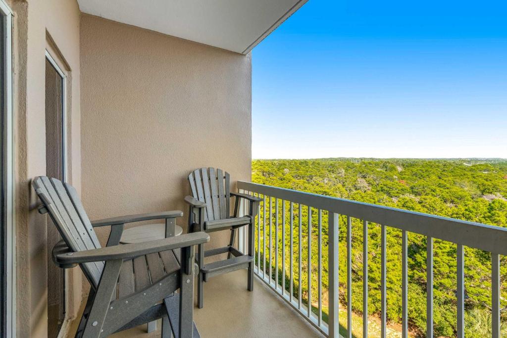 two chairs sitting on a balcony with a view at Condo with Shoreline Views and Resort Pools in Destin