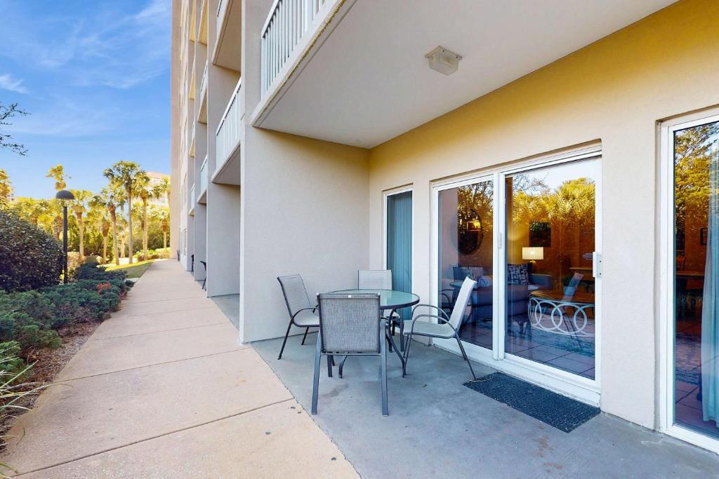 a patio with a table and chairs next to a building at TOPS'L Summit 107b in Destin