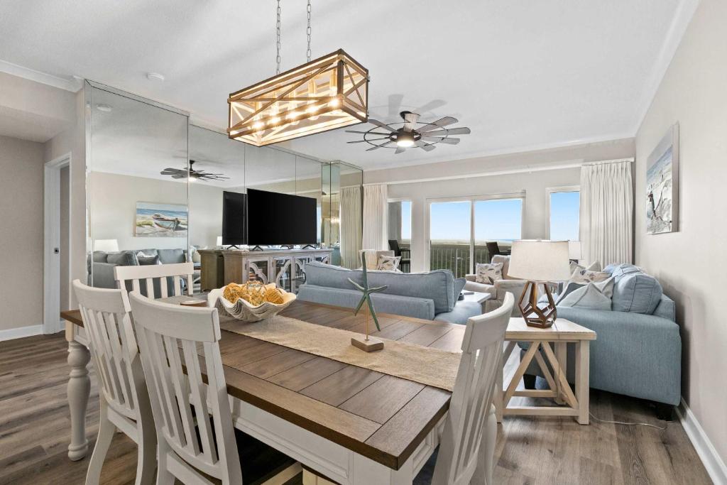 a dining room and living room with a table and chairs at TOPS'L Summit 809 2 Bedroom in Destin