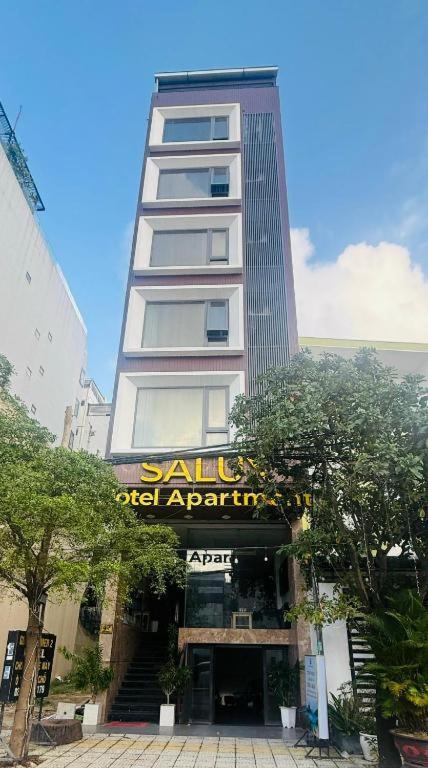 a tall building with a sign in front of it at Salux Hotel in Danang