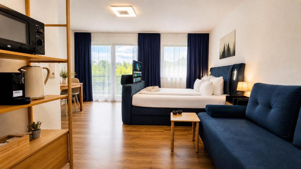 a hotel room with a bed and a couch at KOMM - Panoramablick - Balkon - Küche - Parkplatz in Suhl