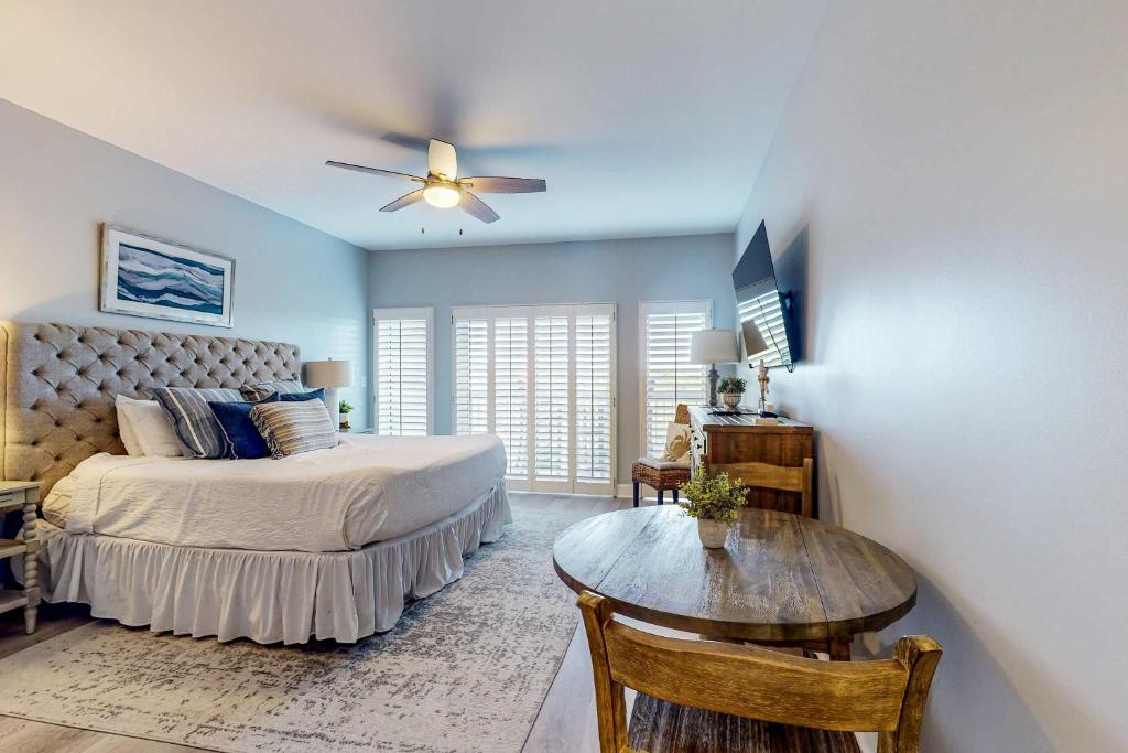 a bedroom with a bed with a ceiling fan and a table at 4th-Floor Condo with Shared Pool and WiFi in Destin