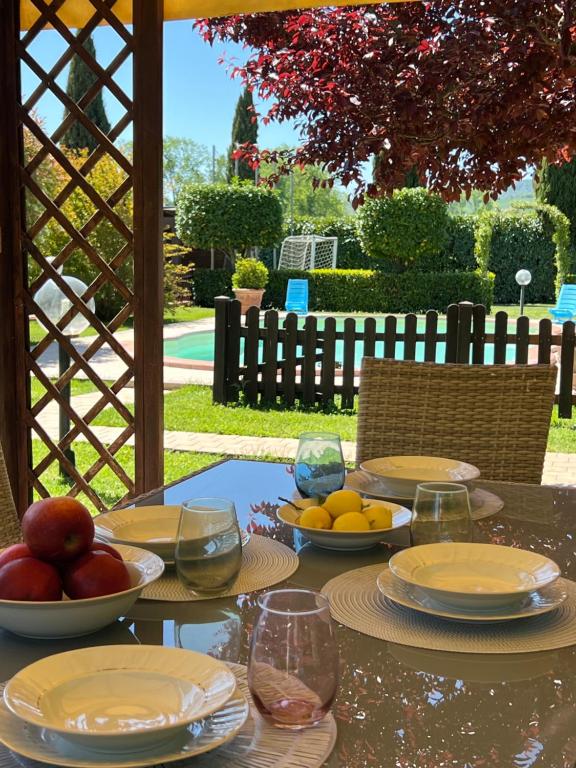 a table with plates and bowls of fruit on it at Relax Home Holiday in Panicale