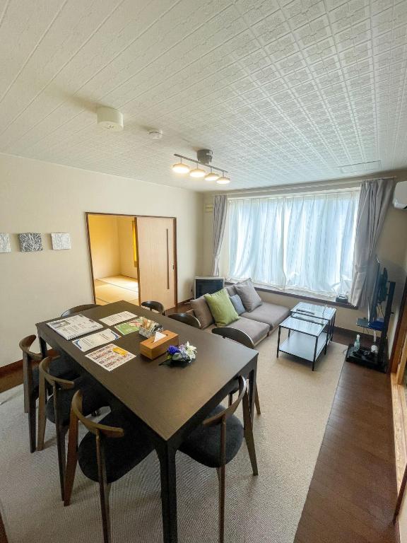 a living room with a table and a couch at Furano Retreat in Furano