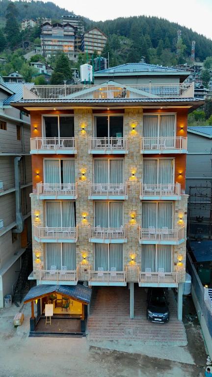 an apartment building with balconies and lights on it at Avasa Boutique Hotel Manali in Manāli