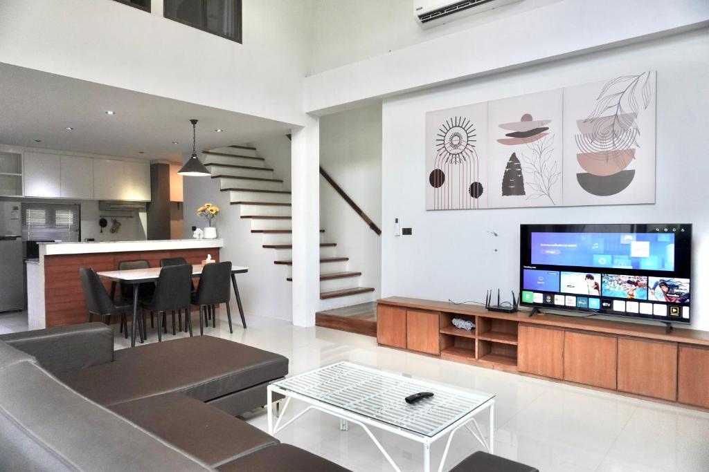 a living room with a couch and a tv and a table at Ana's House in Nathon Bay