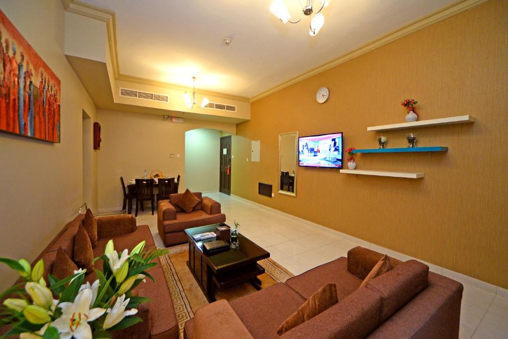 a large living room with couches and a tv at Emirates Stars Hotel Apartments Dubai in Dubai