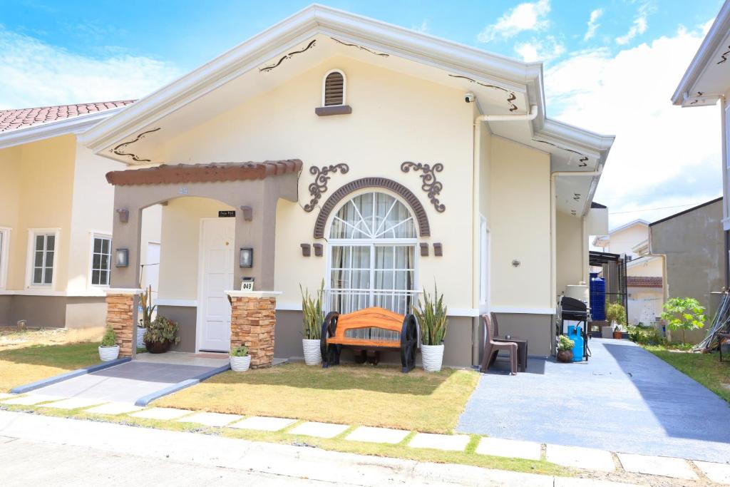 a house with a bench in front of it at 3BR Guesthouse near Panglao - Pool Access - Bohol Tours - Fast WiFi in Dauis