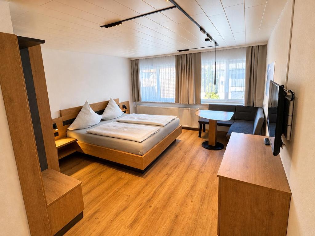 a room with a bed and a couch and a television at Gästehaus Jedinger - Easy Lake Access by Tram in Sankt Georgen im Attergau