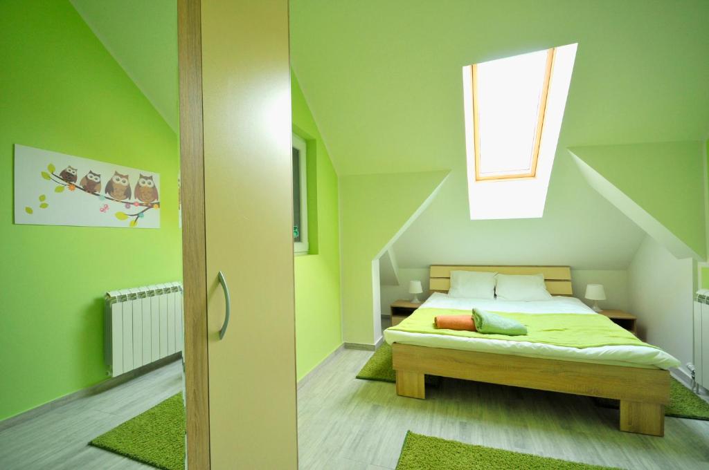 Apartment Sovica في بلغراد: غرفة نوم بجدران خضراء وسرير مع نافذة