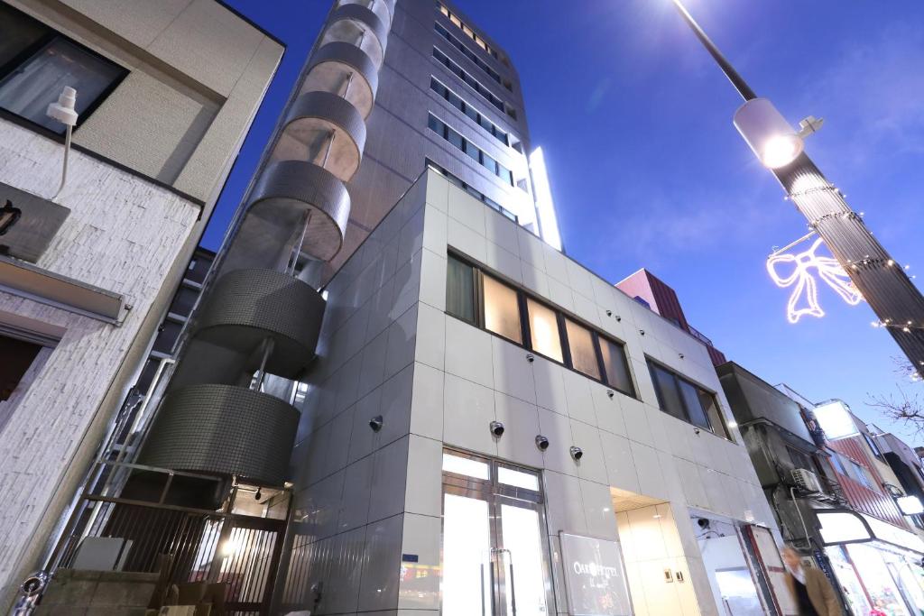 un edificio alto con una torre de TV en el fondo en Oak Hotel Edo, en Tokio