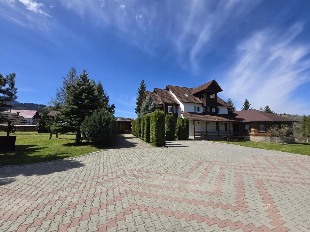 a house with a brick driveway in front of it at Camere de Inchiriat Ceahlau in Ceahlău