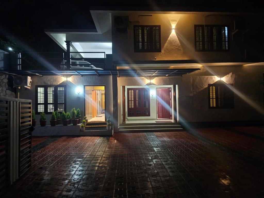 a house with a door at night with lights at Richard's Homestay -Classy AC Rooms in Thiruvalla