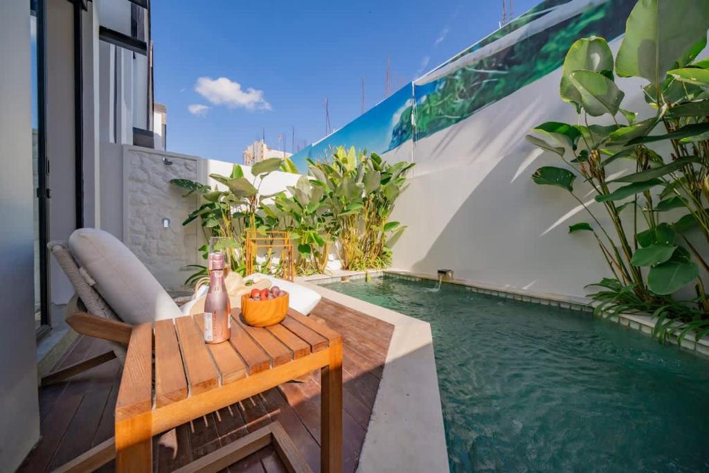 a balcony with a table and a swimming pool at Breezy villa w- pool & beach access in Mengwi