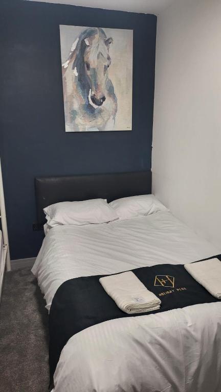 a bedroom with a bed with a painting of a horse at Holiday Plus - 50 Palatine Road in Blackpool