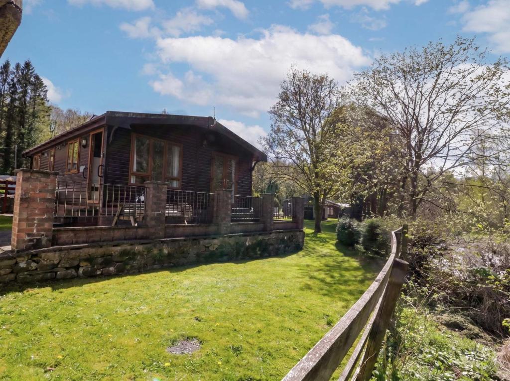 a house in the middle of a yard at Elm Lodge in Keswick