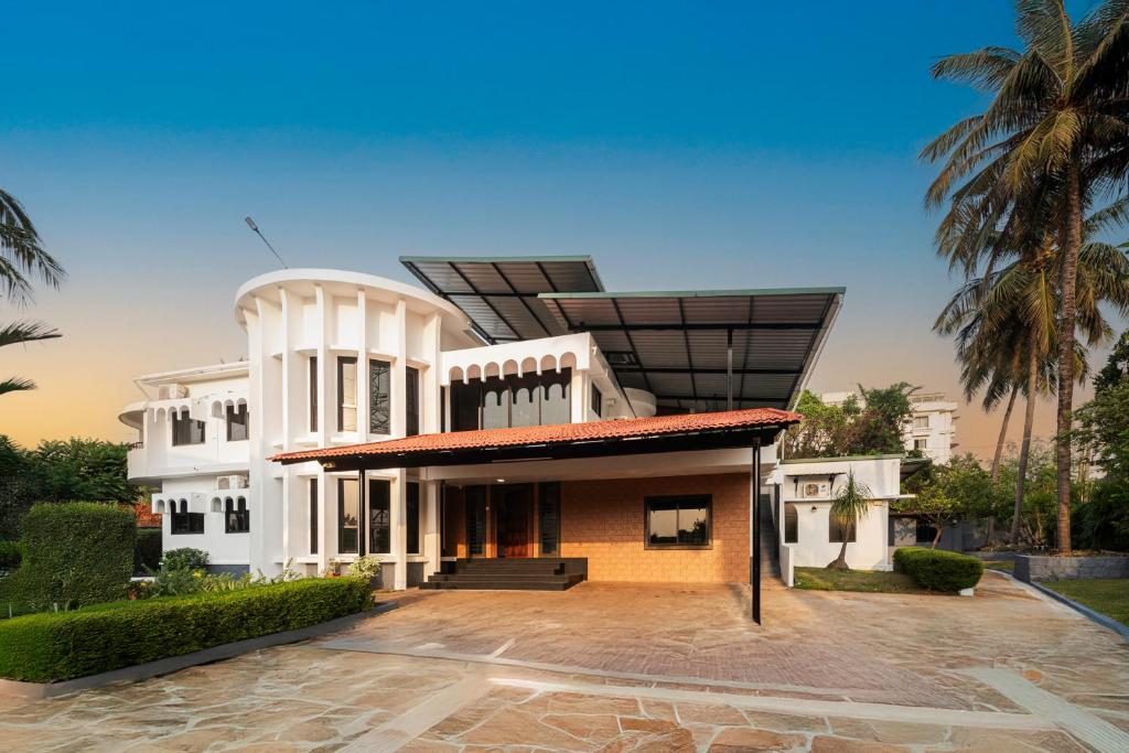 a white house with a solarium on top of it at Shoolin Resorts in Manipal