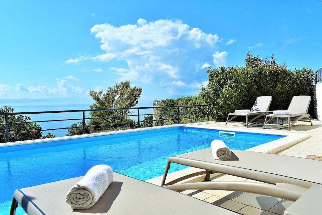 a swimming pool with a view of the ocean at Villa Vedran in Podgora