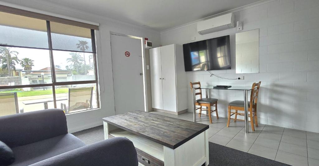 a living room with a table and a dining room at Albatross Motel in Lakes Entrance