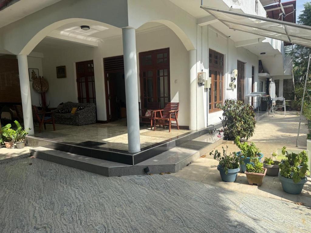 a front porch of a house with potted plants at Verandah 46 Homestay Kandy in Katugastota