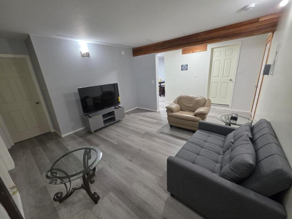 a living room with a couch and a tv at Spacious 3-Bedroom Private Guest Suite in Inuvik