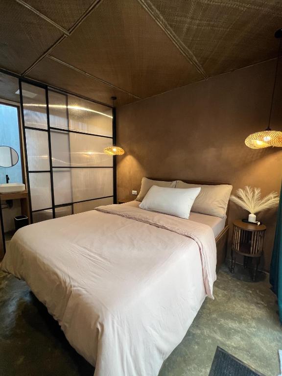a bedroom with a large white bed in a room at Kundiman Siargao, General Luna in General Luna