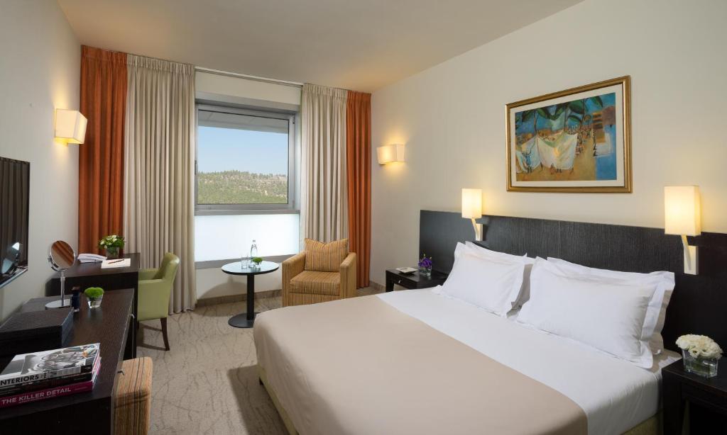 a hotel room with a large bed and a window at Ein Kerem Hotel in Jerusalem