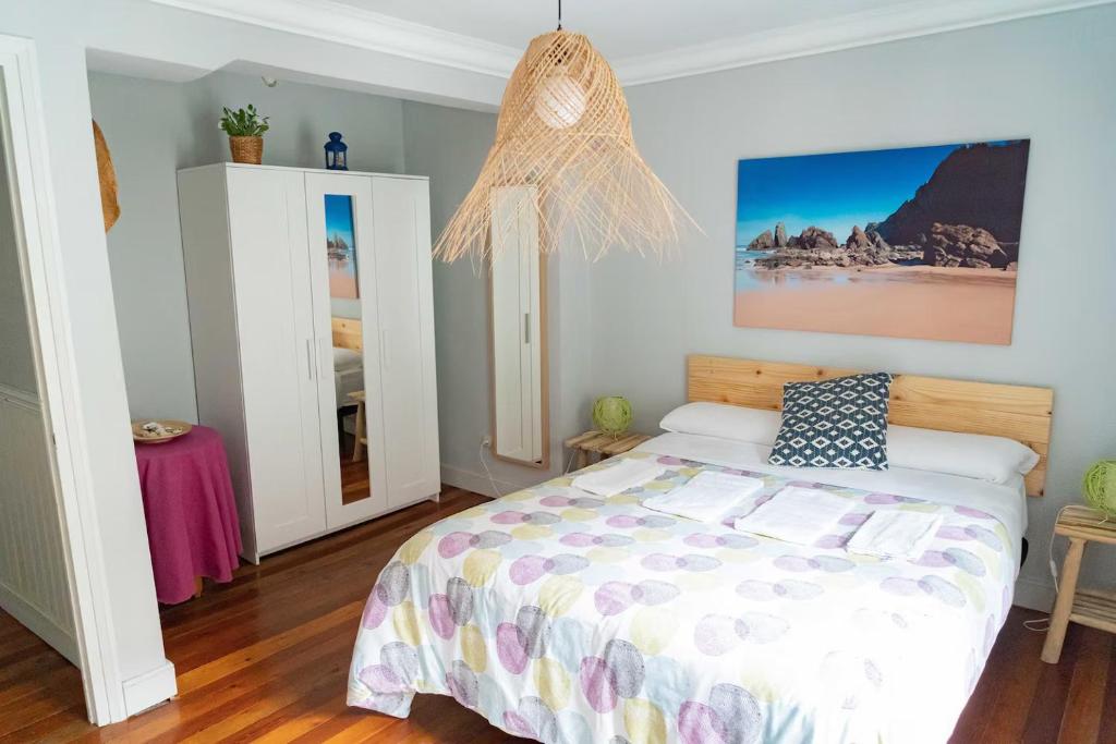 a bedroom with a bed and a chandelier at Apartamento luminoso y espacioso en Urdaibai in Elanchove