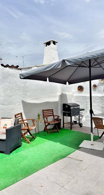 a patio with an umbrella and chairs and a piano at Casa Solua in Reguengos de Monsaraz