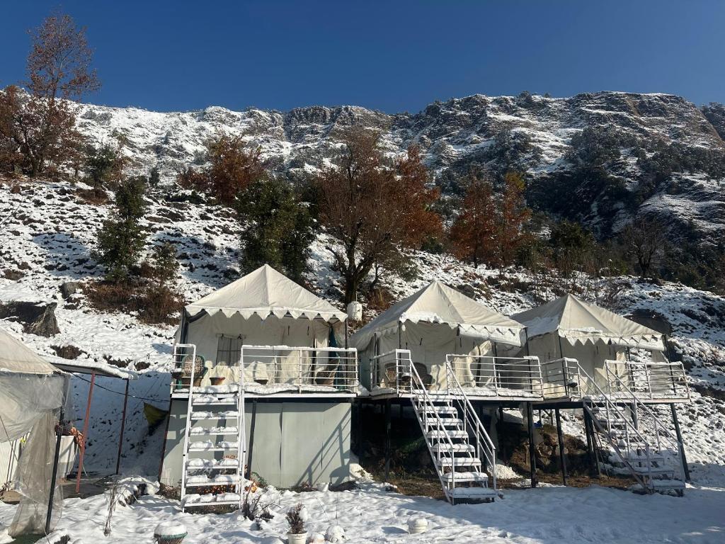 a group of tents in the snow next to a mountain at Sari Highlands chopta Offbeat campsite in Ukhimath