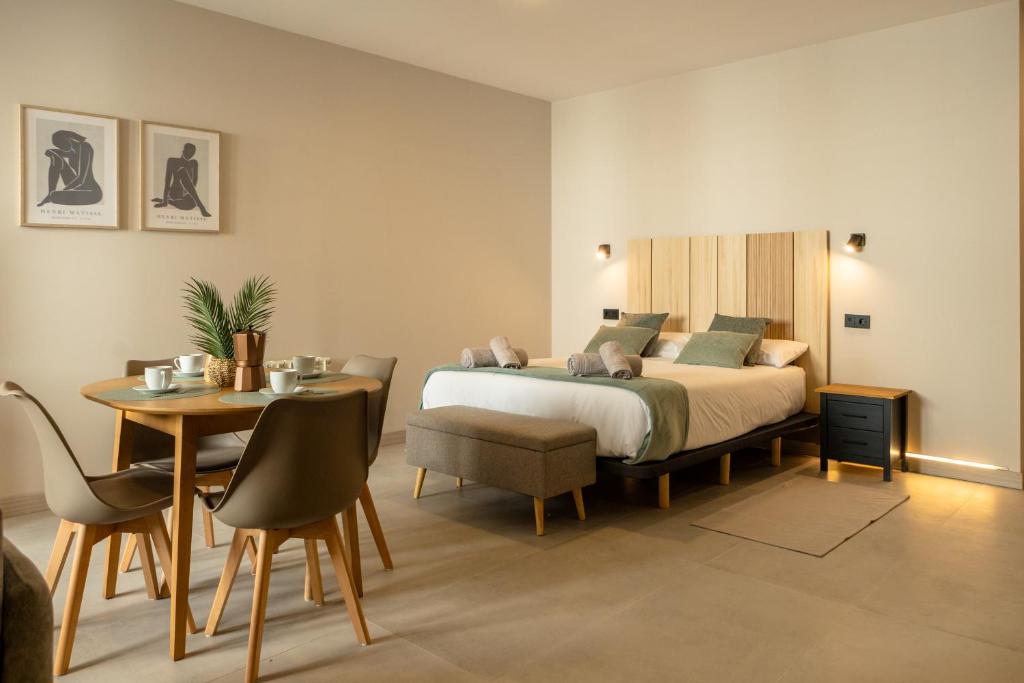 a bedroom with a bed and a table and chairs at Apartamentos Villa De Comillas in Comillas