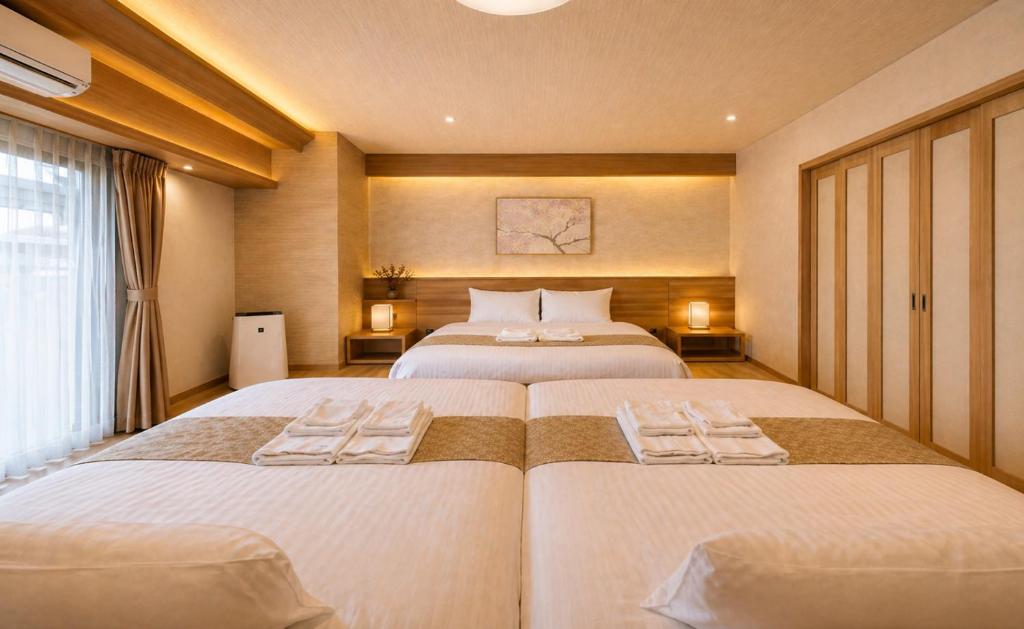 a bedroom with two beds with towels on them at TAKUTO STAY SAKAISUJI-HOMMACHI in Osaka