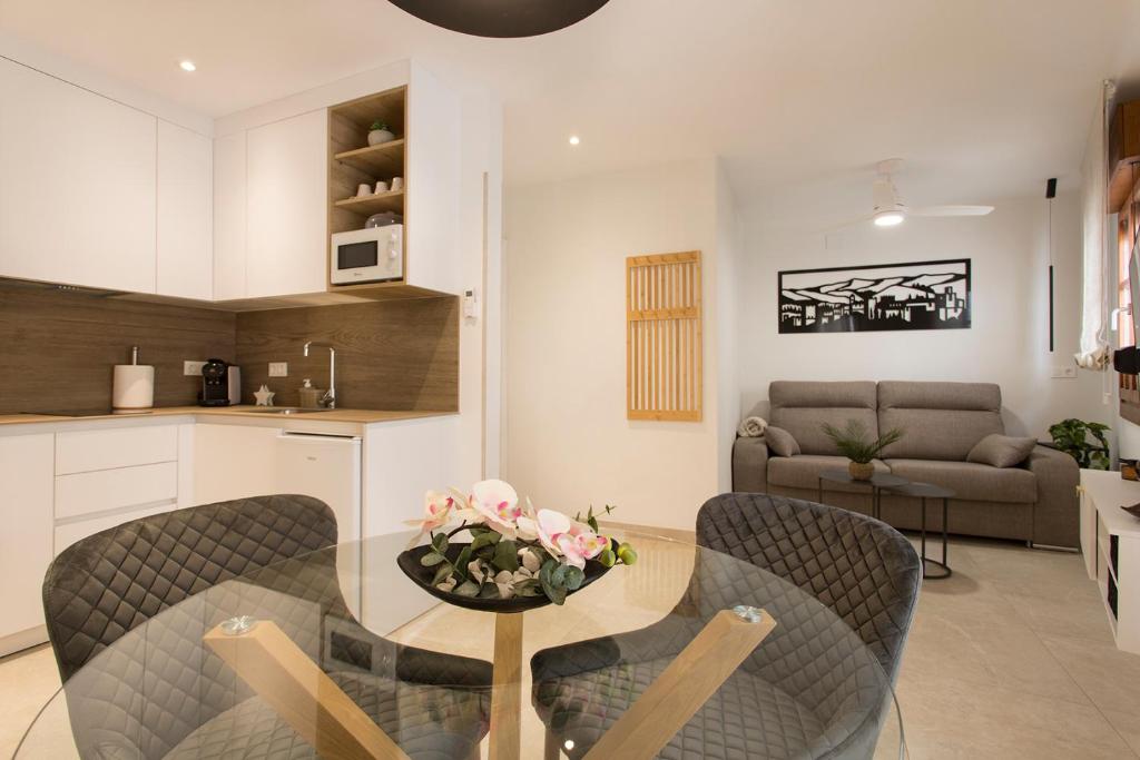 a kitchen and living room with a table and chairs at Apartamento Silleria Reyes Catolicos Centro in Granada