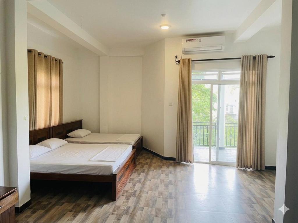 a bedroom with a bed and a sliding glass door at Shanuka homes in Mawanella