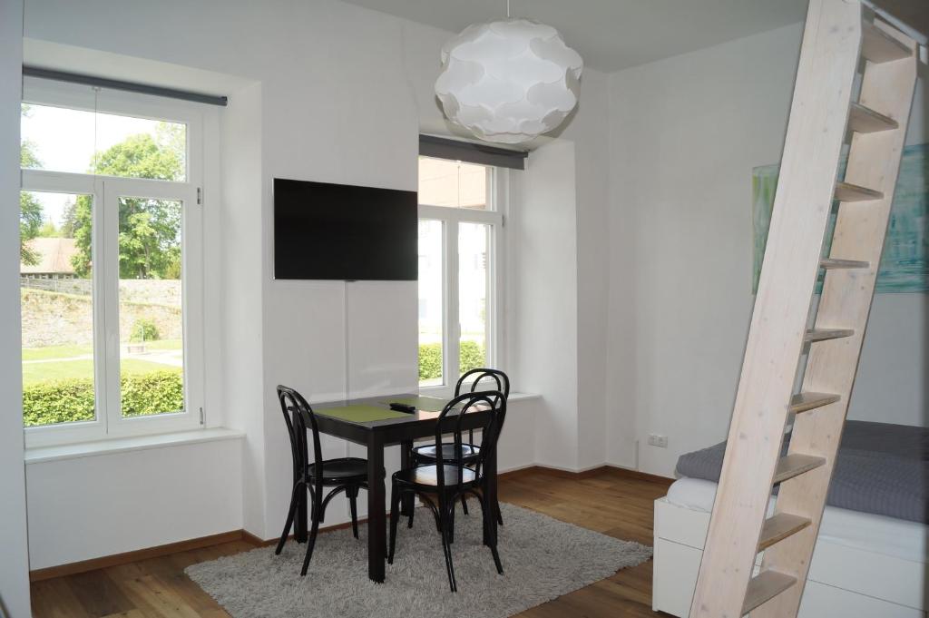 a dining room with a table and chairs and a ladder at Loft Style Studio - historic old town in Villingen-Schwenningen