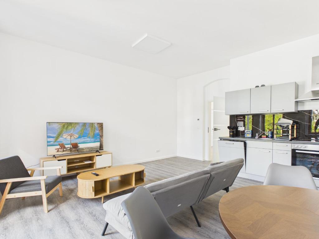 a living room with a table and chairs and a kitchen at Landeskron38 - LK38 in Görlitz