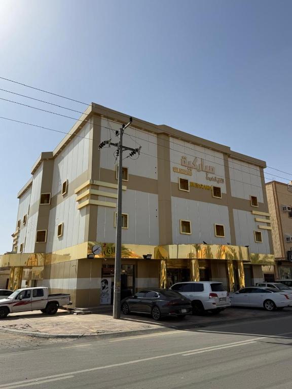 a large building with cars parked in front of it at شقق مباركية in Rafha