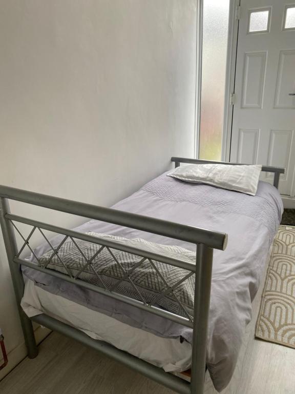 a bed with a metal frame in a room at Varditchy in Redbridge