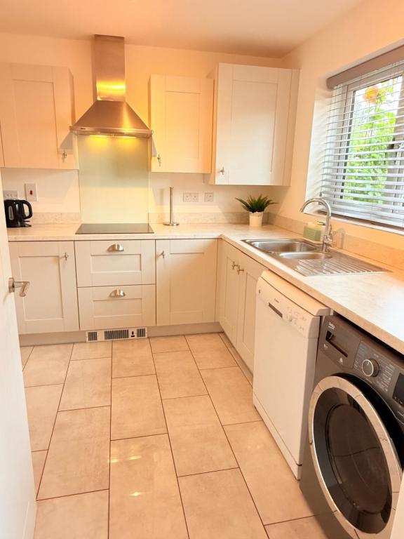 a kitchen with white cabinets and a washing machine at The Vine in Powick