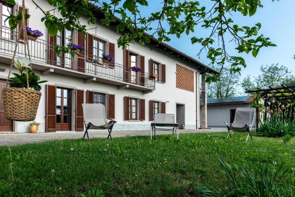 three chairs in the grass in front of a building at Ca' Mariet Langhe in Guarene