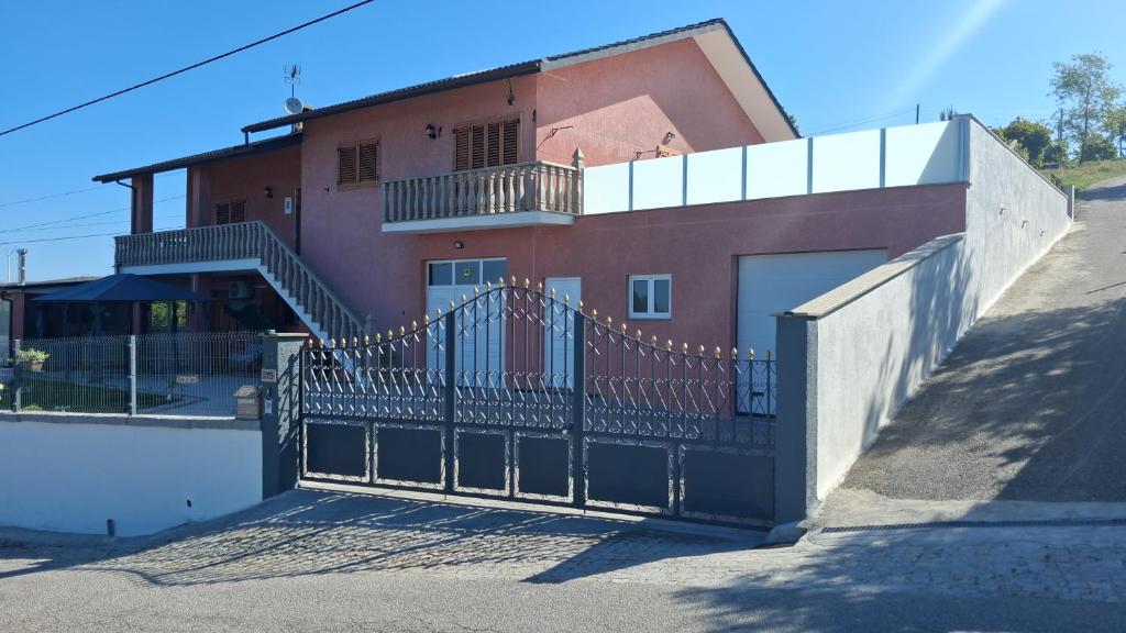 a gate in front of a house with a building at Casa Rosàlia in Castro Daire
