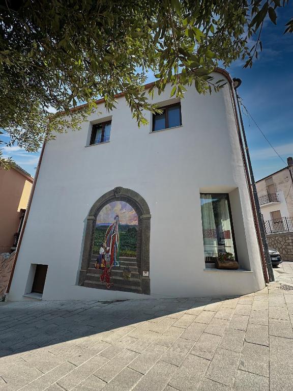 a building with a painting on the side of it at ANTICHE TERRE Di GALLURA in Monti