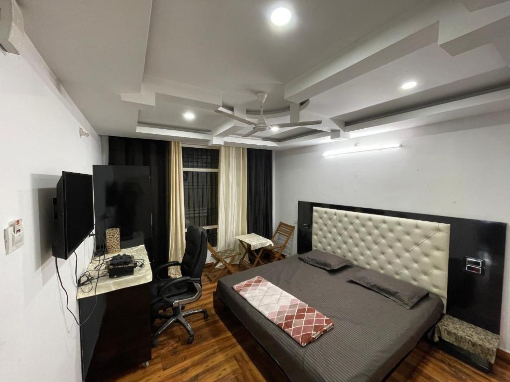 a room with a bed and a desk and a computer at Tatva stays in Dharmsāla