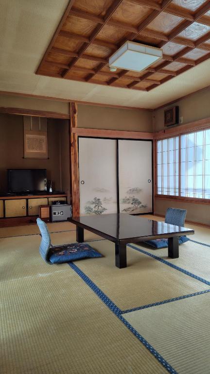 a large room with a table and chairs in it at Ryokan Sarashinaya in Kiso