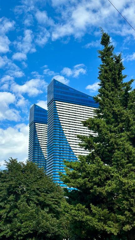 a tall blue and white building with trees in front of it at Batumi Best View in Batumi