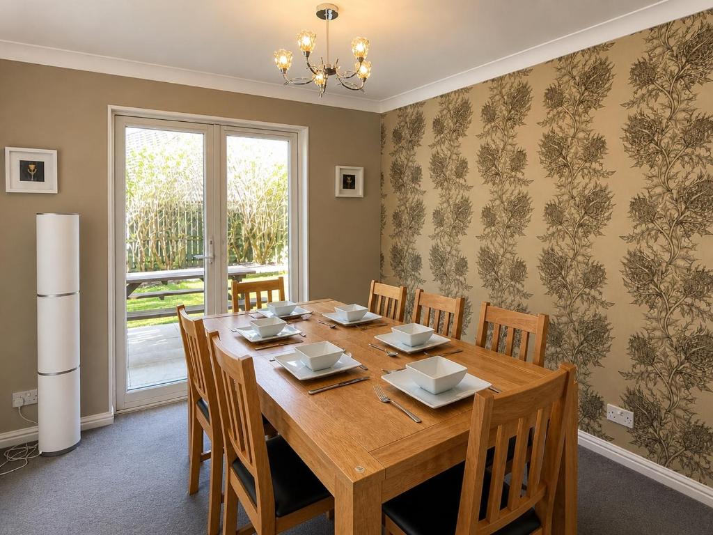 a dining room with a wooden table and chairs at Tigh na Lochan in Aviemore